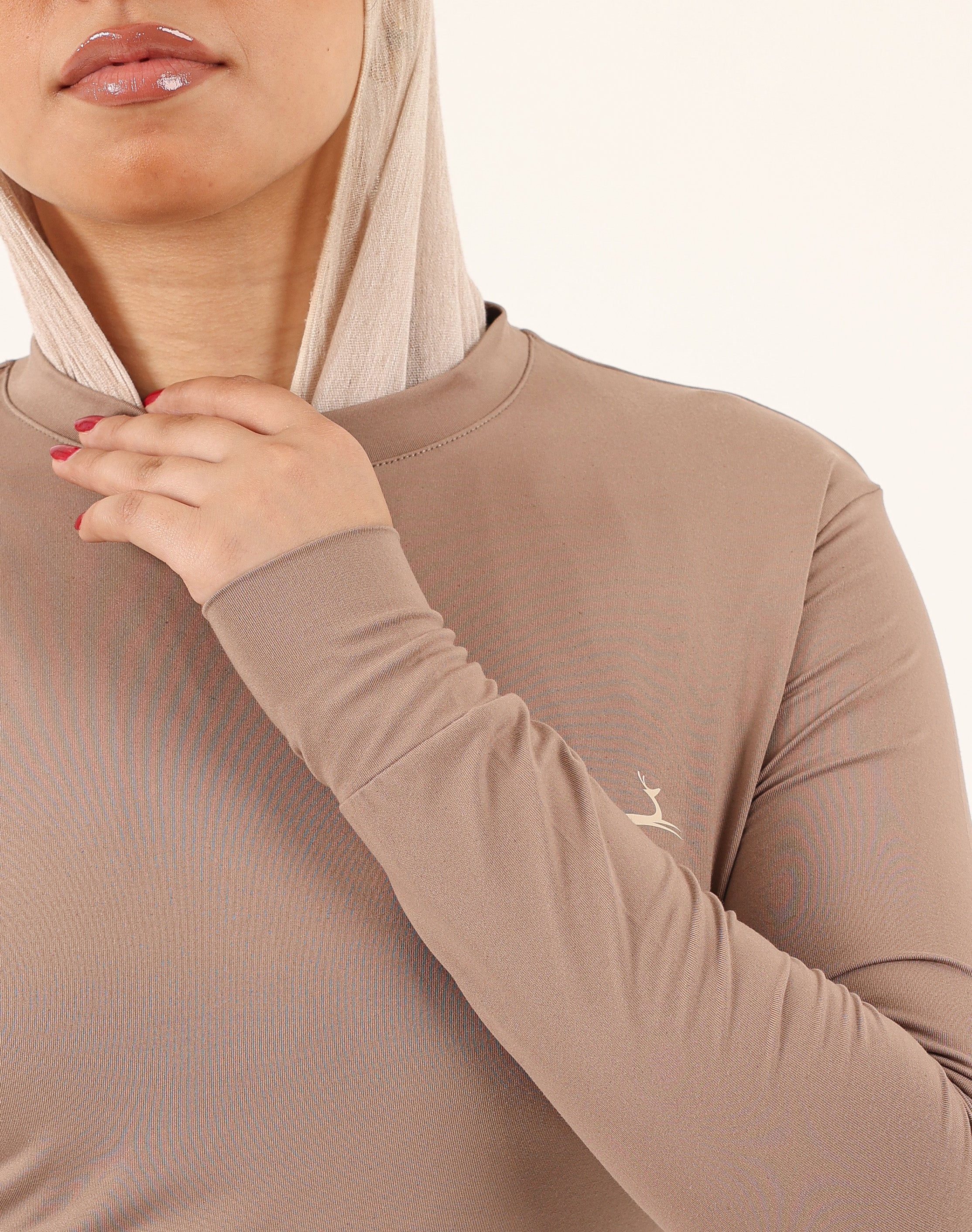 Close-up of soft dry-fit stretch fabric on brown Doe Modest Flow Top